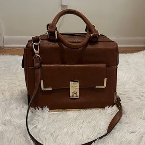 Chestnut colored messenger bag with gold accents.